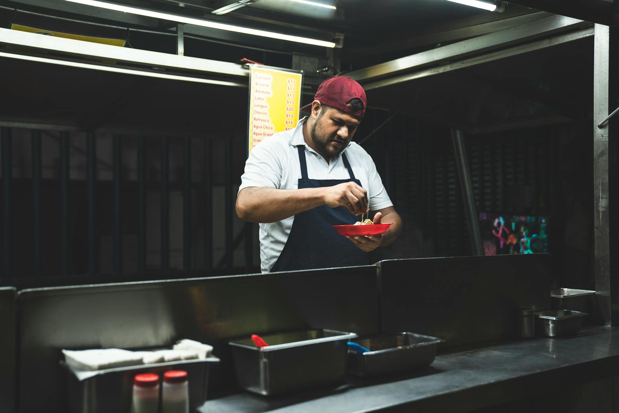 Taco vendor preparing fresh Mexican tacos at a nighttime street food stand.
